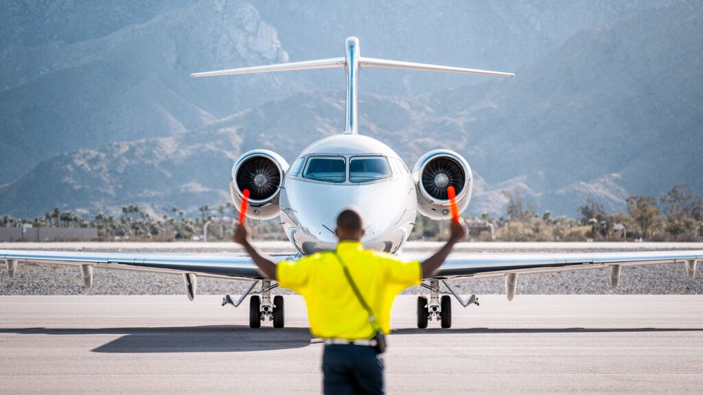 Ground crew directing Gulfstream aircraft for takeoff at Avianese facility